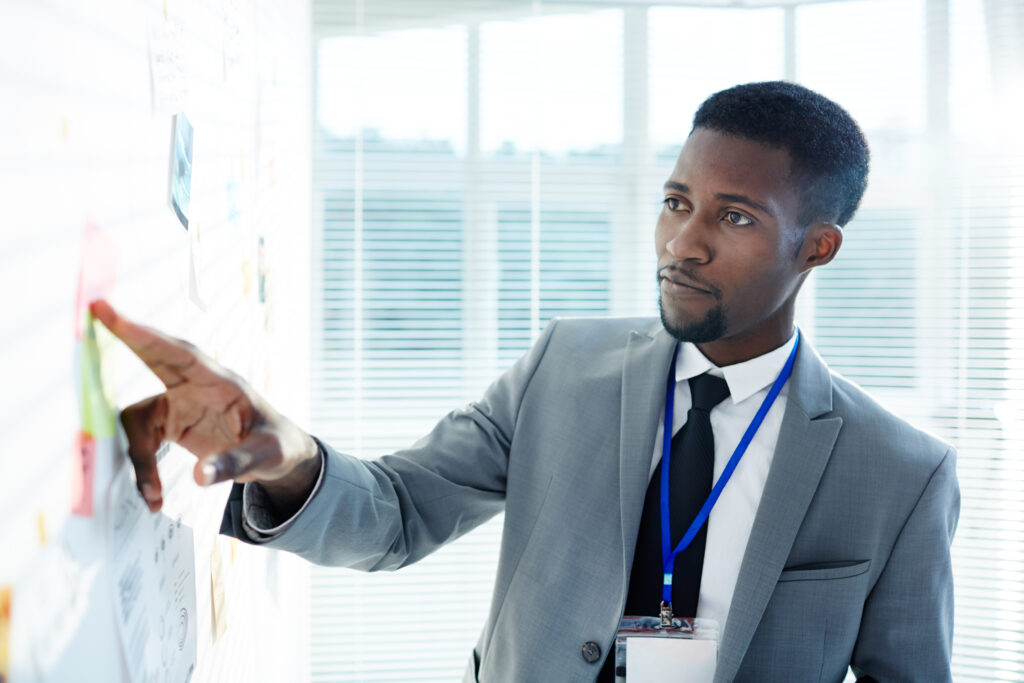 iStock-876209588 - Young inspector in suit pointing at evidence on whiteboard